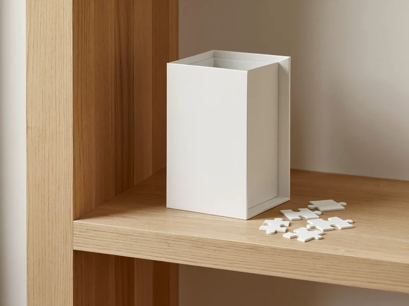 Scatola di puzzle senza testo su una mensola di rovere chiaro
