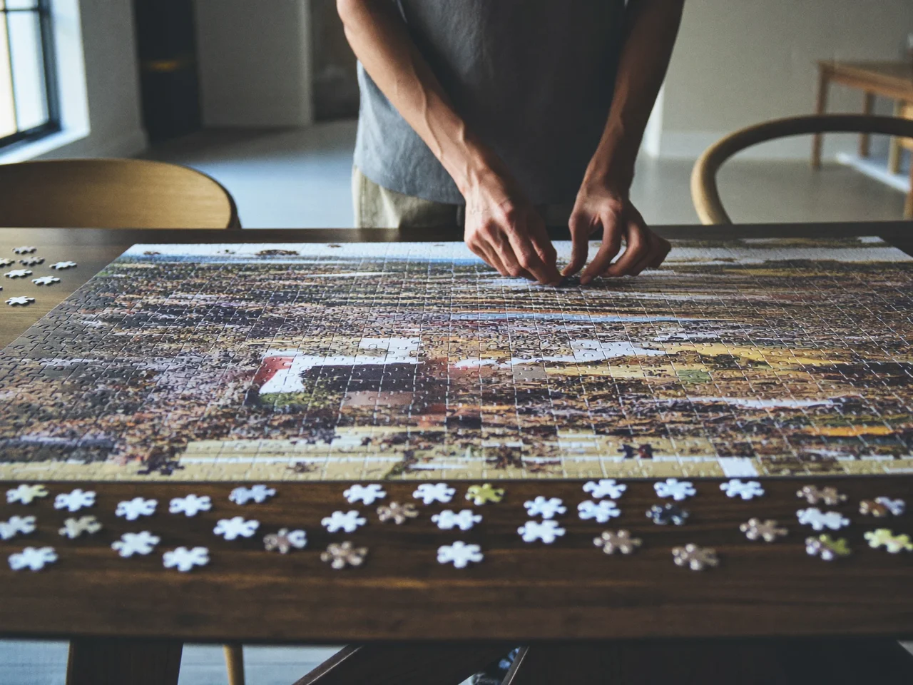 Puzzle paesaggistico in corso di composizione su un tavolo di legno